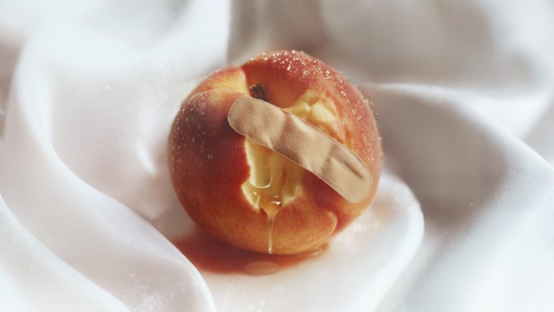 Bild: Angebissener Pfirsich mit Pflaster.