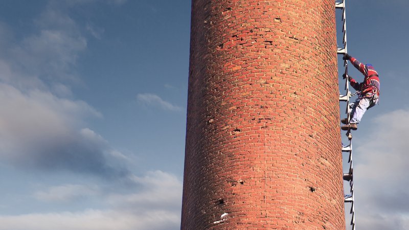 Bild: Mann klettert auf Turm.