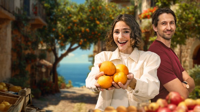 Maya Leinenbach mit frischen Orangen neben René Adler vor südländischem Hintergrund. 
