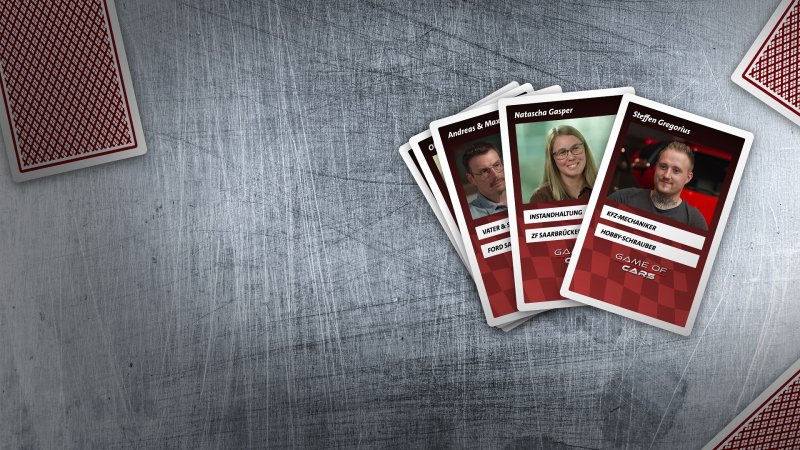 Spielkarten mit Personen liegen gefächert auf einer Metallplatte