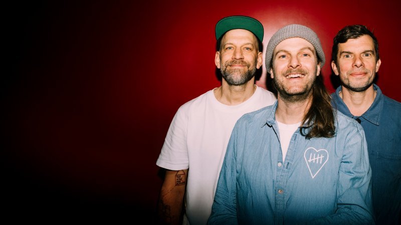 Die Musikgruppe "Sportfreunde Stiller" vor rotem Hintergrund
